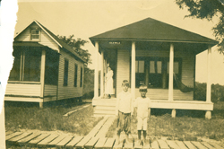 old photograph picturing two children in front of their home
