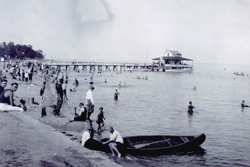Photograph of boats and people sharing the beach